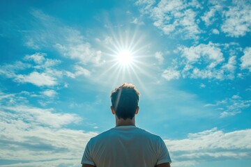 Fototapeta premium Young caucasian male under bright sunlight with clear blue sky