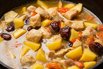 In a frying pan, chelnt is stewed with potatoes, beans, onions, meat, spices