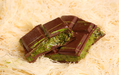 Dubai chocolate pieces with kataifi text background