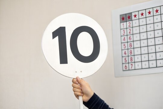 Hand Holding a Scorecard with a "10" Displayed