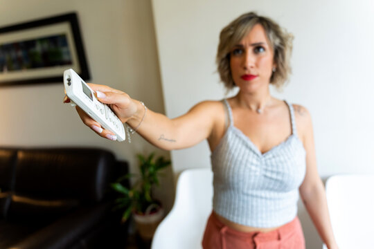 Woman turning on air conditioning during hot summer day