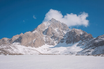 A mountain covered in snow with a blue sky in the background