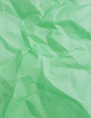 Crumpled green recycled paper texture with natural wrinkles and creases. Minimalist background.