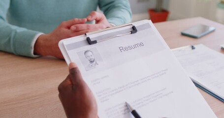 Close up of HR professional reviewing job applicant resume during interview. Employer analyzing candidate work experience and qualifications, asking questions. Human resources and recruitment concept.
