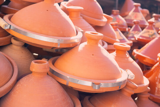 terracotta tagines, traditional plates, cookware, local shop in Marrakech&rsquo;s Medina, vibrant souks filled with traditional Moroccan detailed patterns and cultural artistry