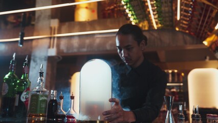 Asian bartender serving mist smoky classical mixing whiskey cocktail fantastic presentation, recommending special welcome tasty creative advertisement drink at beverage counter bar luxury. Vinosity.