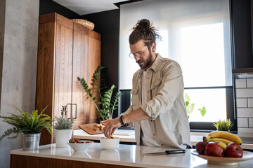 Man preparing healthy breakfast with fresh fruit in modern kitchen