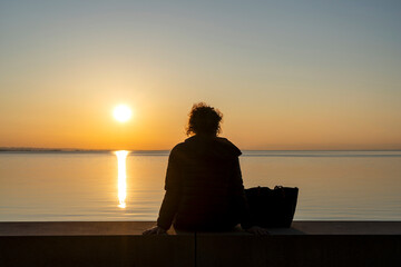 Silhouette of a woman watching the sunset of lake constance / Bodensee with negative space for text