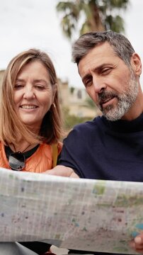 Couple of tourists sightseeing city street with map. Happy husband and wife enjoying vacation together