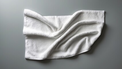 Fototapeta premium Mockup of a white terry towel with a label set against a plain background. Fashionable laid-out towel template for wiping, branding, and design. Product photography in a horizontal format.
