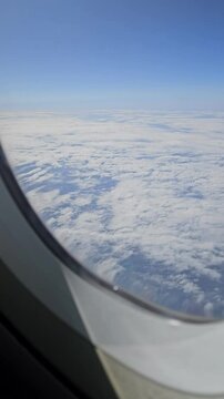 View of the sky and the ground from a plane window while traveling. 