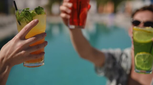 Friends joyfully celebrating together with colorful cocktails at a sunny poolside during a funfilled day