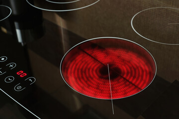 Close-up of heated electric stove coils cooktop in home kitchen.