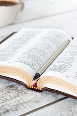 Obraz premium Open holy bible book with pen and cup of coffee. Close-up. Selective focus. Studying and reading Christian Scripture, biblical concept.