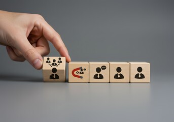Fototapeta na wymiar Hand Placing Cube with Team Icon Near Magnet Icon with People and Communication Symbols - Business Concepts.