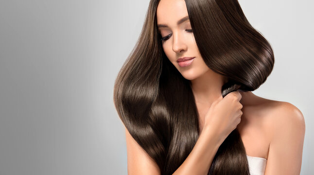 Beautiful model girl with shiny brown and straight long  hair . Keratin  straightening . Treatment, care and spa procedures. Smooth hairstyle
