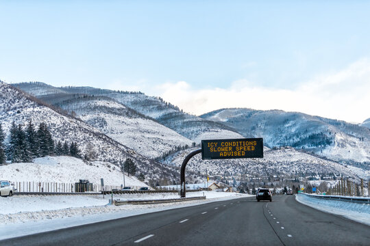 Vail, Colorado rocky mountains on Interstate 70 cars traffic to ski resorts snow with sign for icy conditions