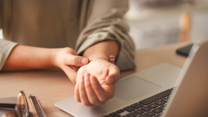 Business woman with wrist pain working a computer