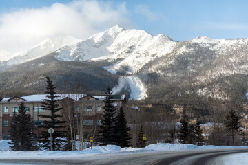 Frisco, Colorado snow capped rocky mountains peak in winter weather sunrise and modern houses apartment condo buildings on street road