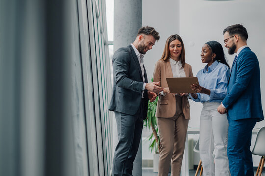 Business team analyzing data on tablet in modern office