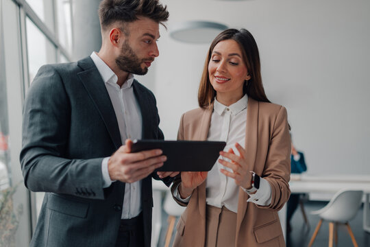 Business colleagues using digital tablet in modern office - Powered by Adobe