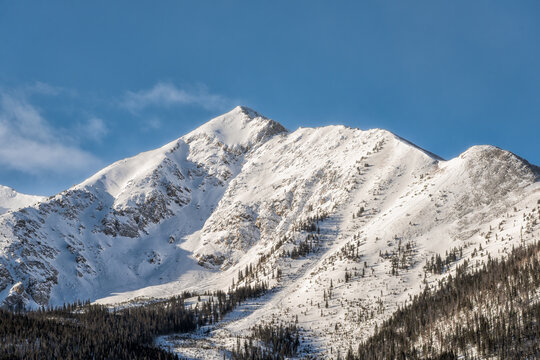 Frisco, Colorado snow capped rocky mountains peak one closeup in winter weather sunrise sunlight and blue sky landscape