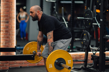 Determined bodybuilder lifting weights in modern gym