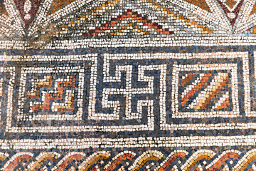 Detailed ancient Roman mosaic featuring geometric patterns, interwoven designs, and vibrant tesserae on a floor of ruined ancient church in Hurvat Beit Loya, Israel