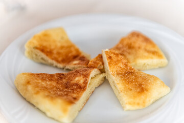 Moddizzosu potato bread traditional Sardinian food slices pieces macro closeup on white plate in Sardinia restaurant, Italy