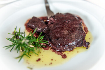 Entrecote ribeye beef steak meat in red wine sauce, balsamic vinegar, rosemary garnish on white plate as Sardinian traditional dish
