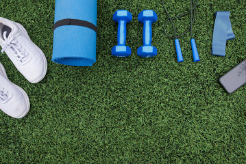 fitness equipment on green grass background. Sports equipment, sports accessories on grass. Concept of sports, fitness.