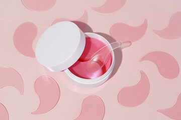White mockup jar with pink hydrogel patches and pattern on pink background. Eye care, moisturizing and skin tightening concept