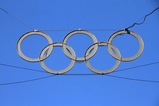 Close-Up of Olympic Rings Monument Hanging Between Towers at Berlin Olympiastadion Against Clear Blue Sky