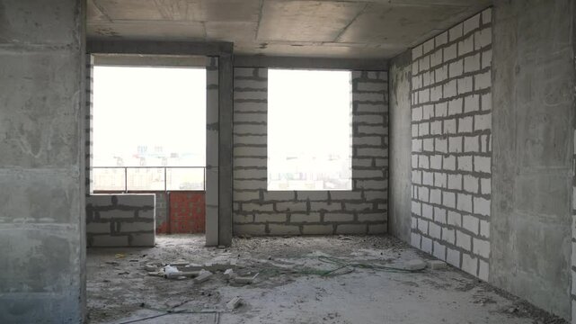 Construction workers are building a white brick wall inside a new apartment, creating a comfortable living space