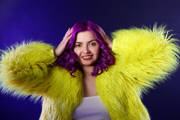 Beautiful woman with bright purple hair on blue background