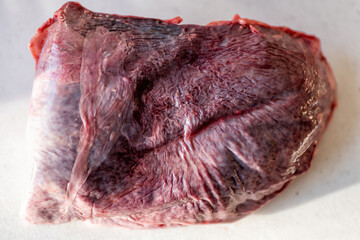 Cow beef spleen organ meat raw uncooked on cutting board in kitchen home room in Virginia macro closeup