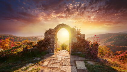 Ancient stone archway at sunset. Old magical portal. Beautiful landscape.