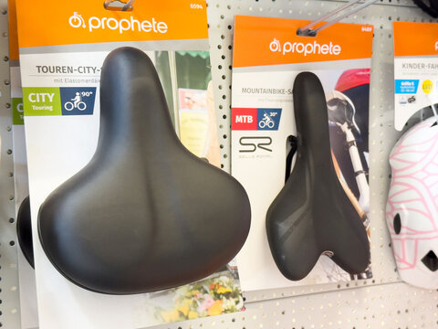 Bicycle saddles displayed on store shelf for city touring and mountain bikes