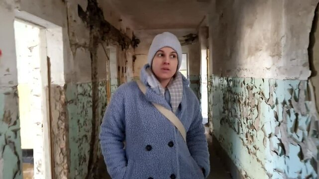 KISKUNMAJSA, HUNGARY - FEBRUARY 22. 2025: Young woman in an abandoned and ruined Soviet barracks 