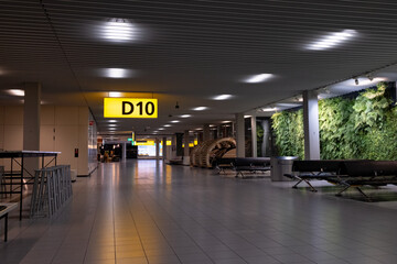 Empty airport terminal waiting area with gate d10 sign