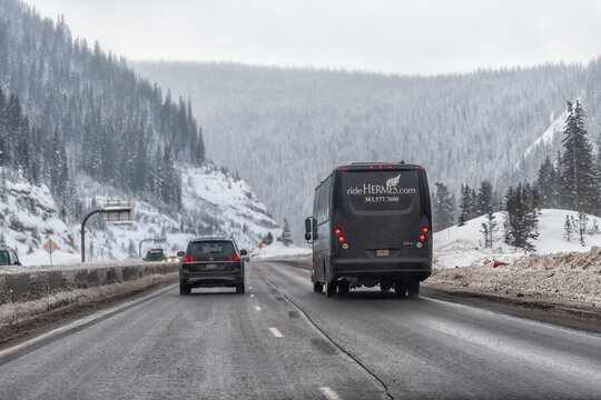 Vail, USA - December 16, 2022: Colorado winter highway road driving pov in snow flurry with van truck ski shuttle bus for ride Hermes luxury service