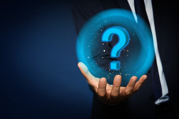 Businessman holding virtual sphere with question mark on dark background, closeup