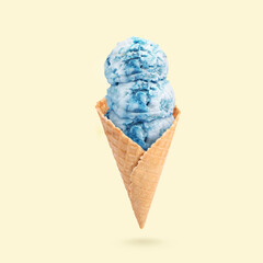 Yummy ice cream served in waffle cone in air on beige background
