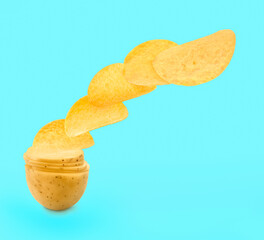 Raw potato slices transforming into crispy chips in air on turquoise background