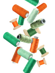 Spools of colorful sewing threads falling on white background