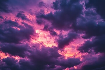 Obraz premium Dramatic sunset sky filled with vibrant purple and pink clouds. casting a captivating glow over a serene landscape. perfect for nature-themed backgrounds or artistic projects