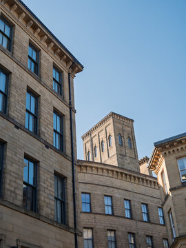 group of 19th century neoclassical buildings in the Bradford Little Germany District looking upwards from a street corner