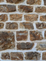 Old church wall with random handmade bricks and masonary old surface