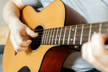 Close-up of a man's hands playing the guitar and strumming chords