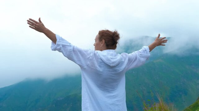Woman by fogy mountains. A woman resting between mountains in fog during traveling time.